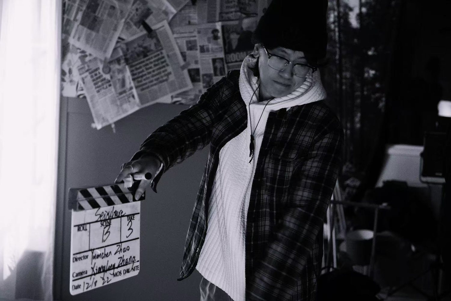 Ivo Tian on a film set with a clapperboard